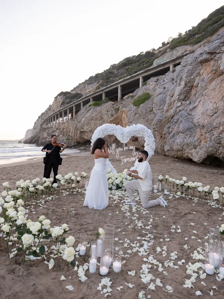 Ginesta beach marriage proposal setup with white roses and cliffs 10