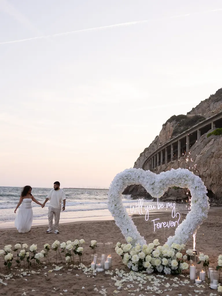 Ginesta beach marriage proposal setup with white roses and cliffs 11