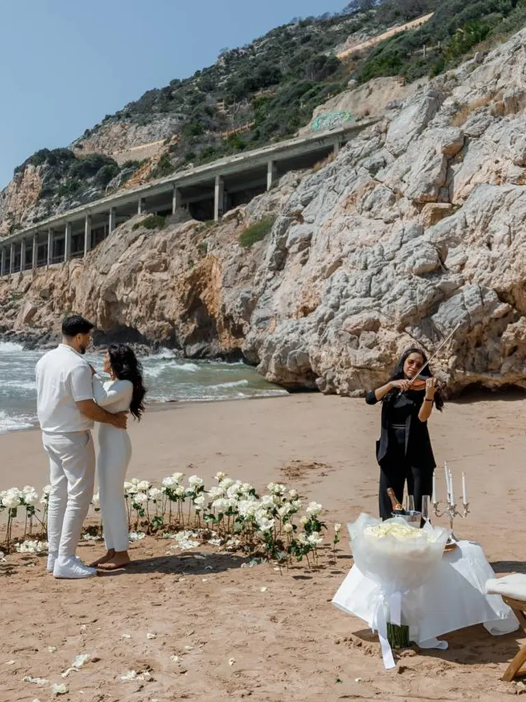 Ginesta beach marriage proposal setup with white roses and cliffs 2