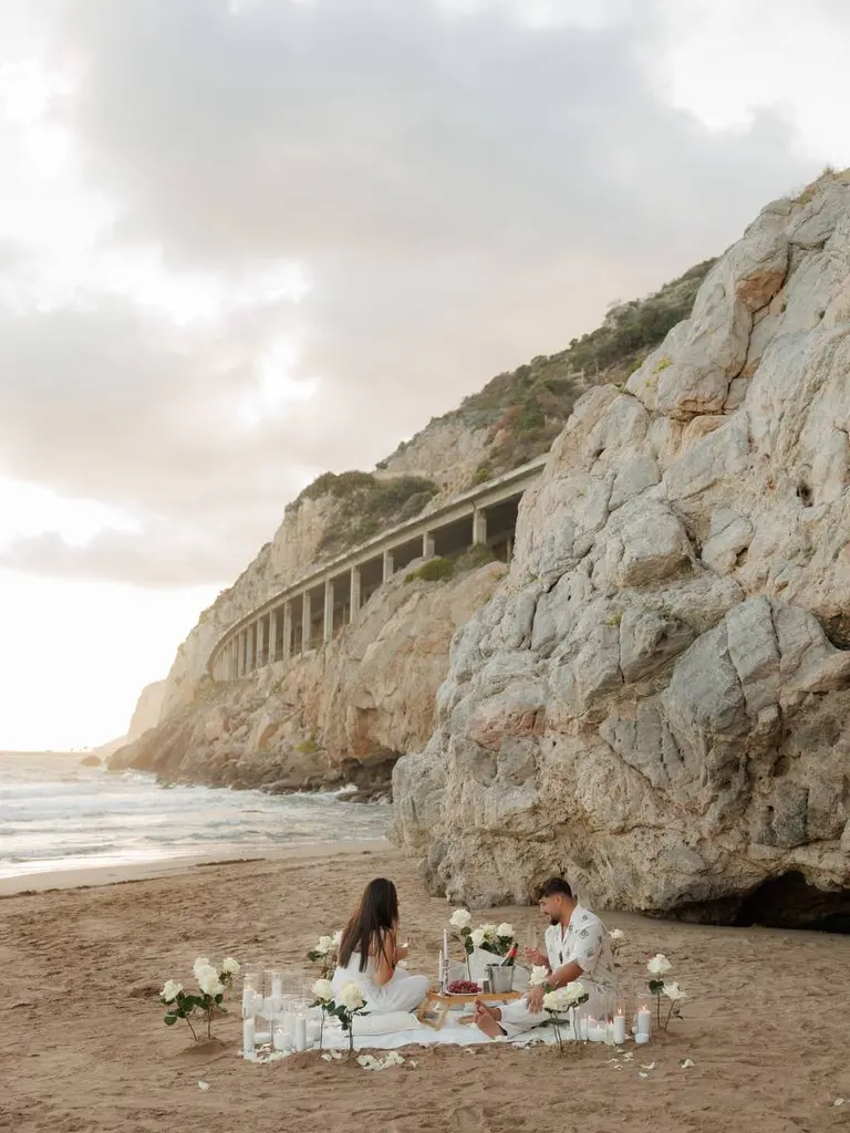 Ginesta beach marriage proposal setup with white roses and cliffs 5